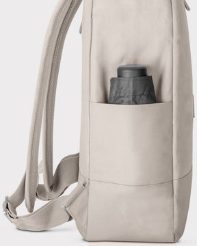 Seitenansicht des hellgrauen Rolltop Rucksacks 'Robin Large' mit einer seitlichen Tasche und einem schwarzen, eingesteckten Gegenstand