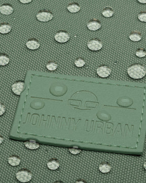 Grünes wasserdichtes Gewebe mit wasserabweisenden Tropfen und Johnny Urban Logo auf einem Rolltop Rucksack