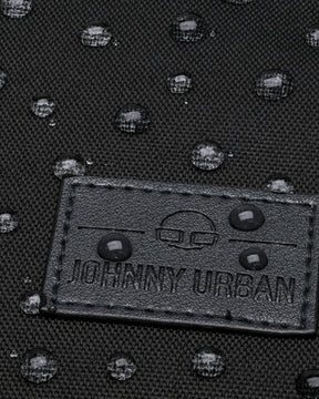 Nahaufnahme eines Gewebematerials mit Johnny Urban Logo und wasserabweisenden Wassertropfen darauf