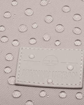 Nahaufnahme des Johnny Urban Logos auf einem wasserabweisenden Rolltop Rucksack Stoff mit Wassertropfen