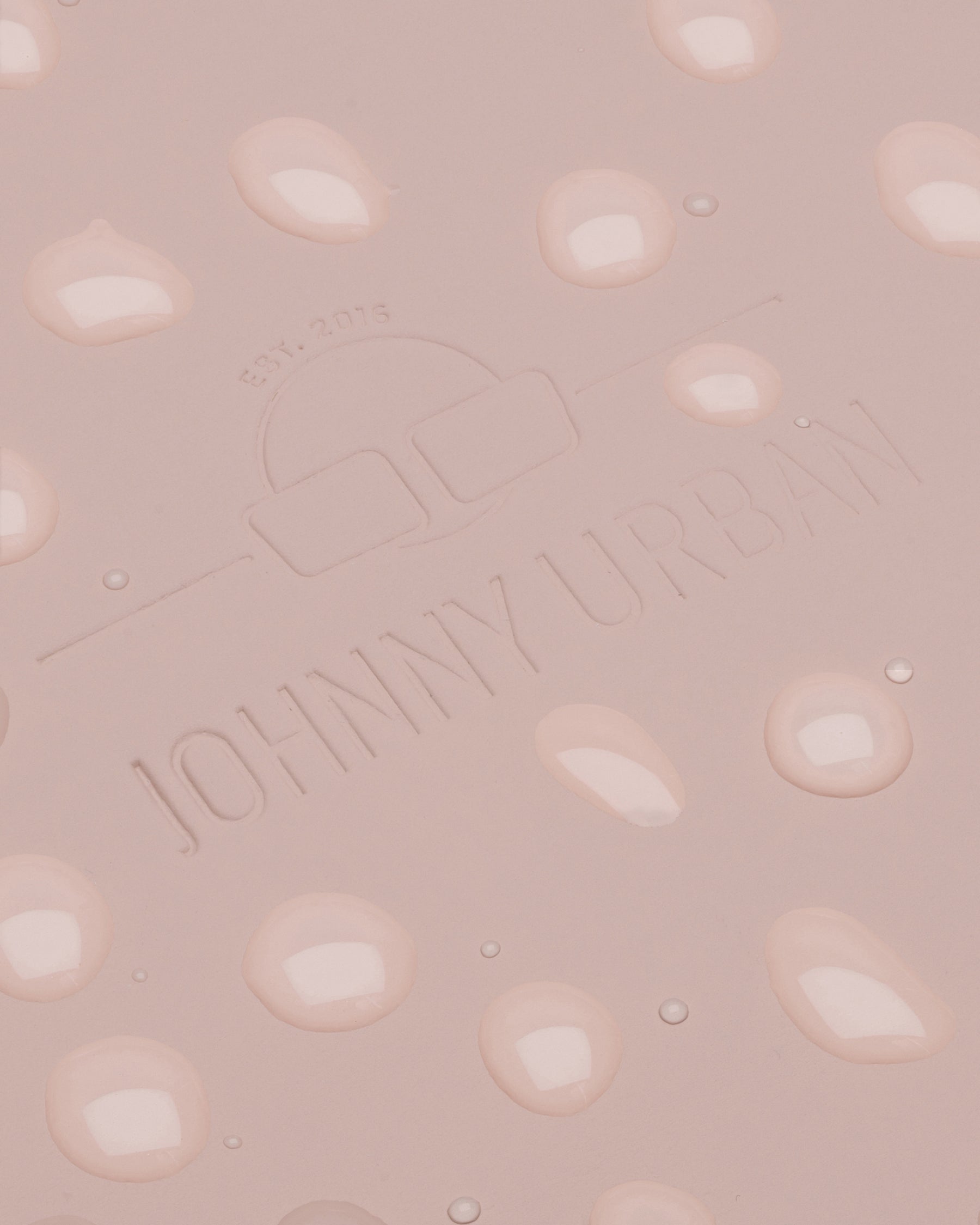 Nahaufnahme des rosa, wasserdichten Rolltop-Rucksacks Henry mit eingeprägtem Johnny Urban Logo und Wassertropfen