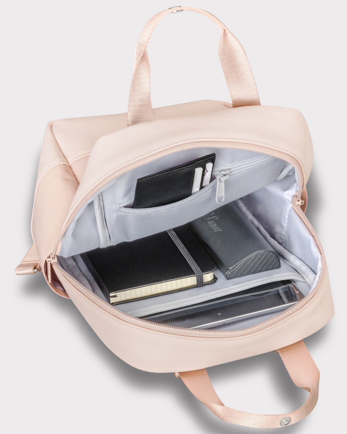 Heller Rucksack 'Jona Small' mit geöffnetem Hauptfach und innen liegendem schwarzen Notizbuch, Brillenetui und Geldbörse