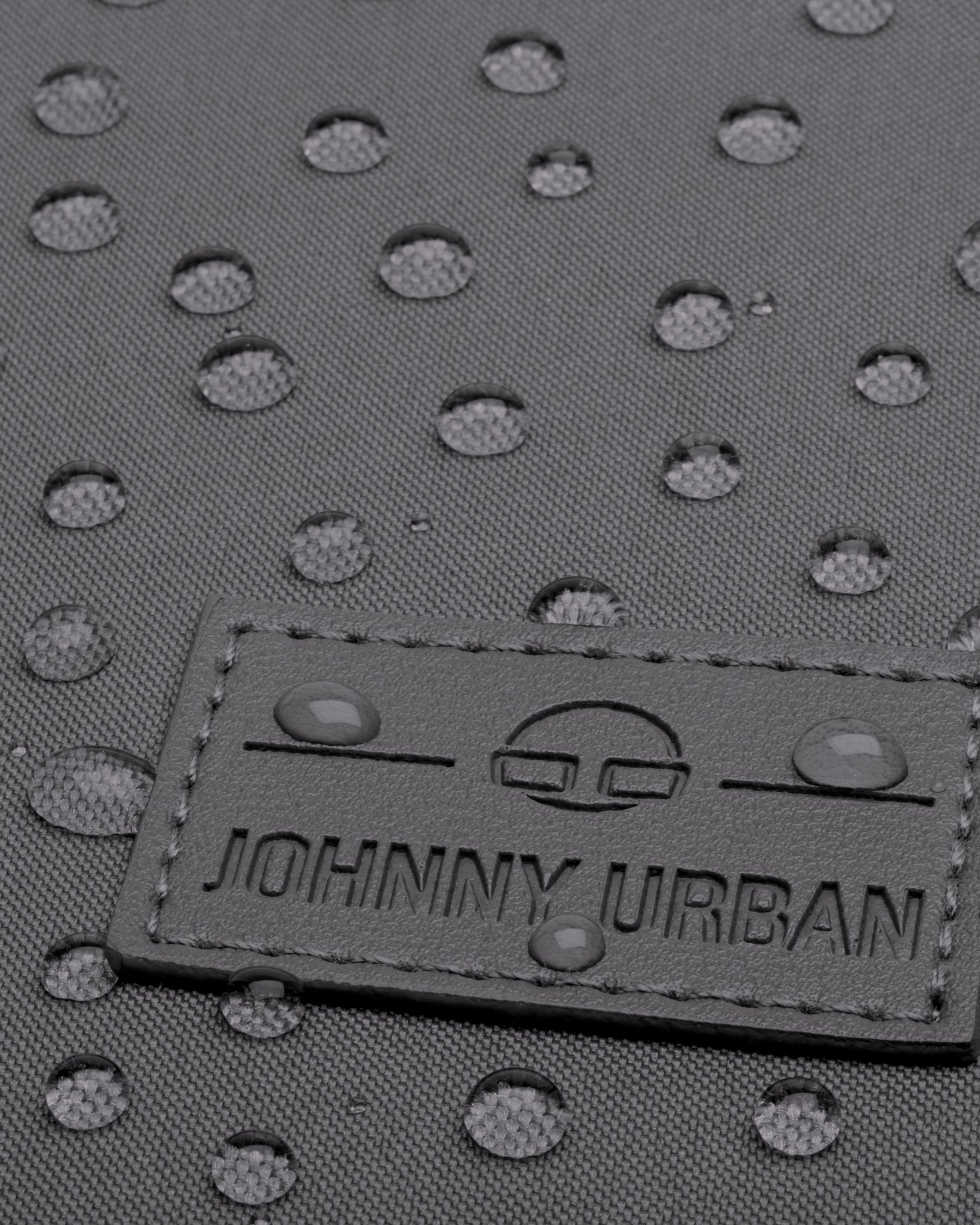 Detailaufnahme des wasserabweisenden grauen Gewebes und des Johnny Urban Logos auf dem Rucksack Jona Large