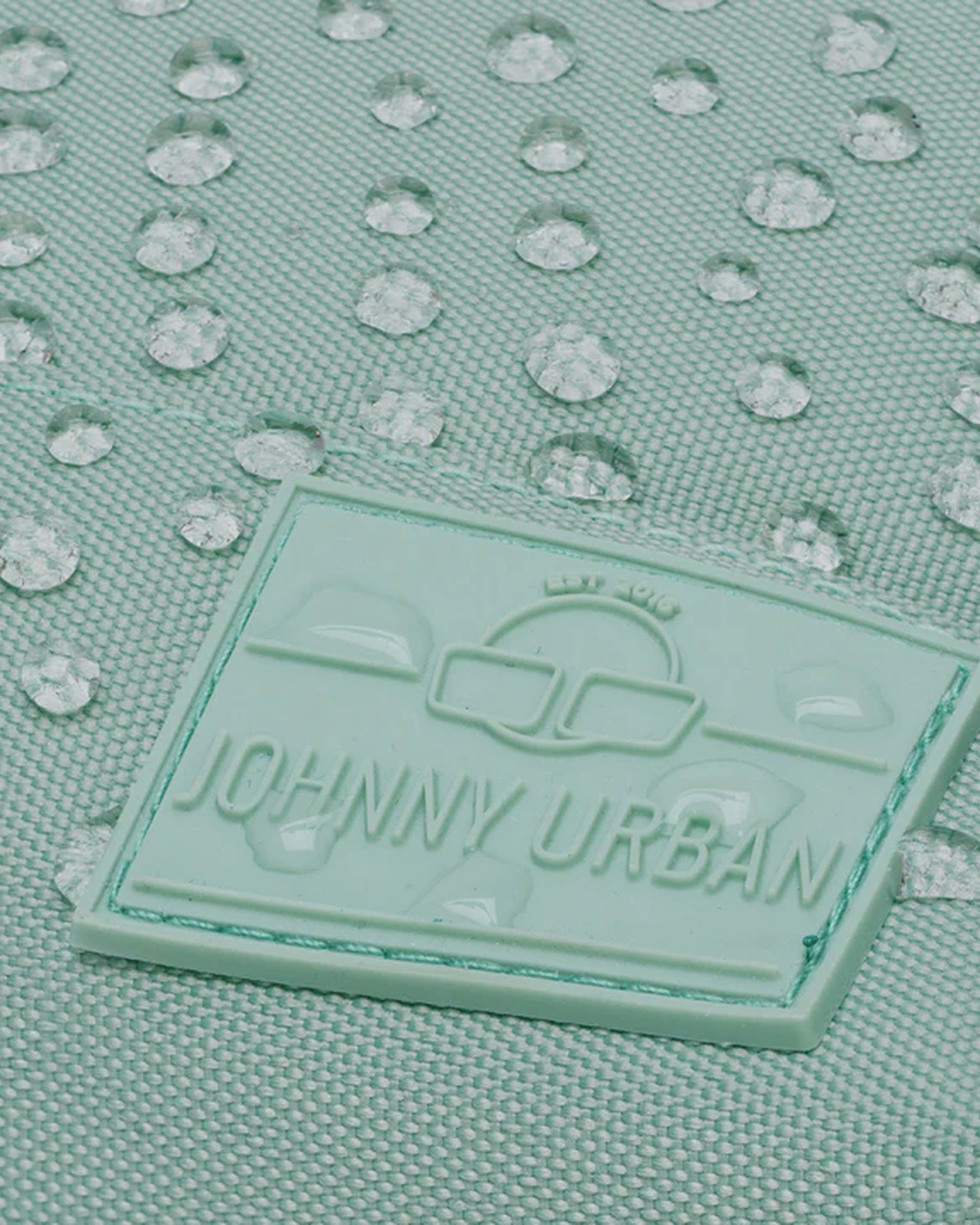 Mintfarbener Rucksack 'Mia' von Johnny Urban mit Wasserperlen auf der Oberfläche