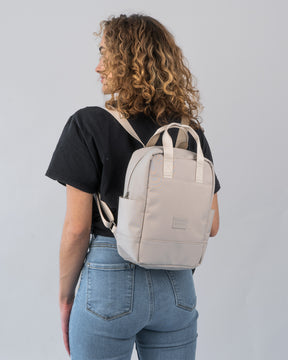 Frau mit schwarzen T-Shirt und Jeans trägt beige Rucksack 'Jona Small' von Johnny Urban