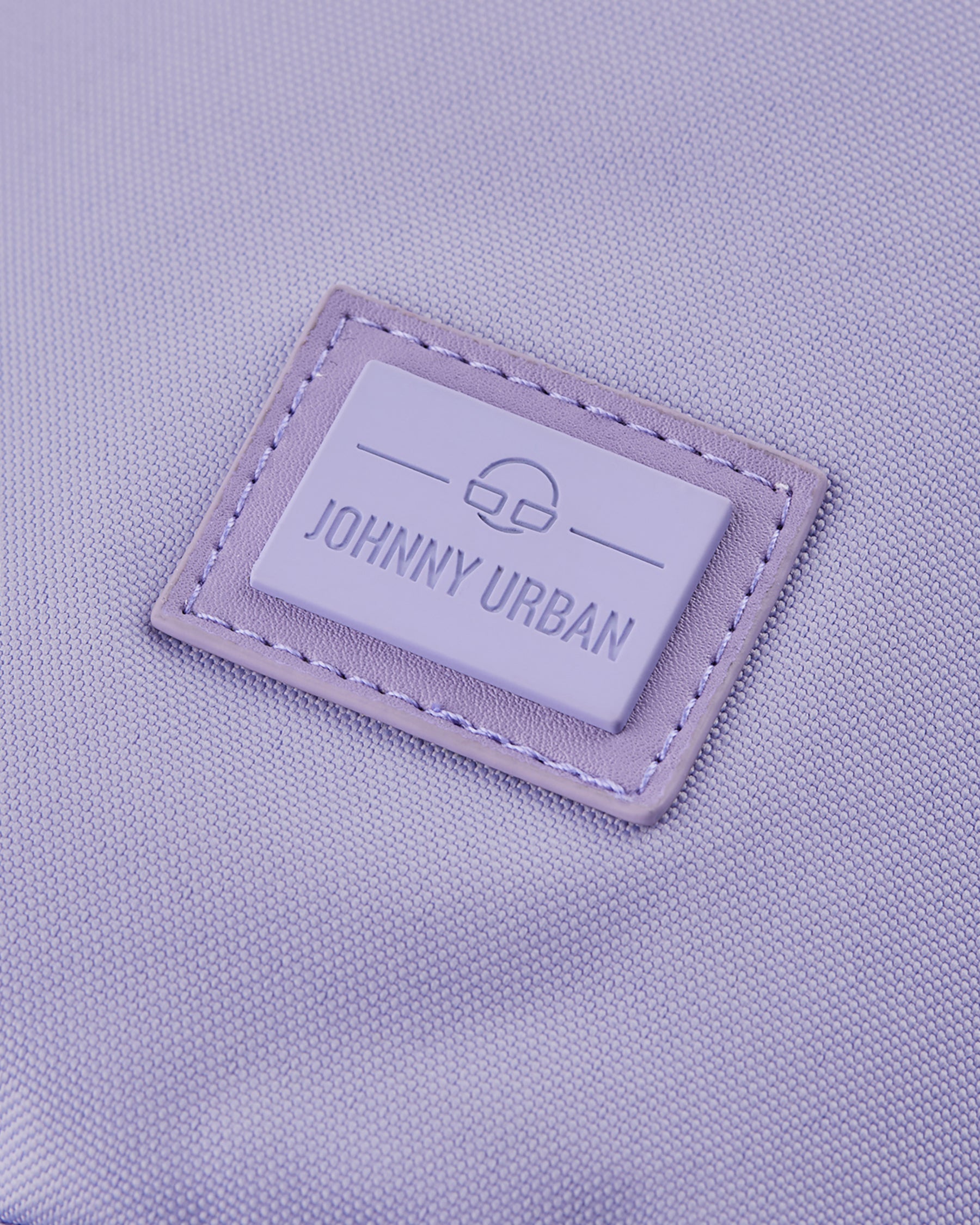 Nahaufnahme des Johnny Urban Logos auf violettem nachhaltigem Stoff der Umhängetasche 'Rue'