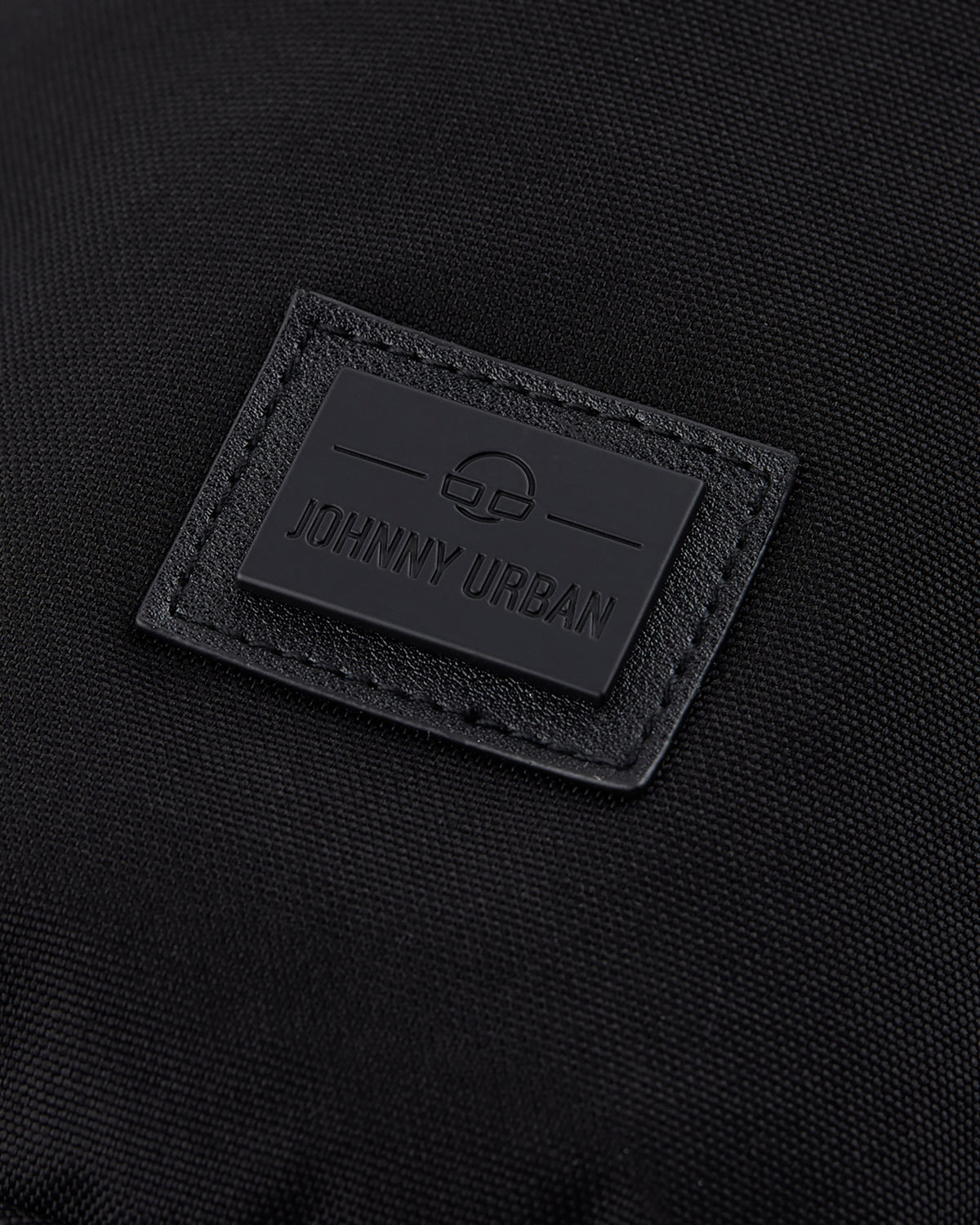 Schwarzes Logoetikett mit Schriftzug 'Johnny Urban' auf nachhaltiger Umhängetasche 'Rue'