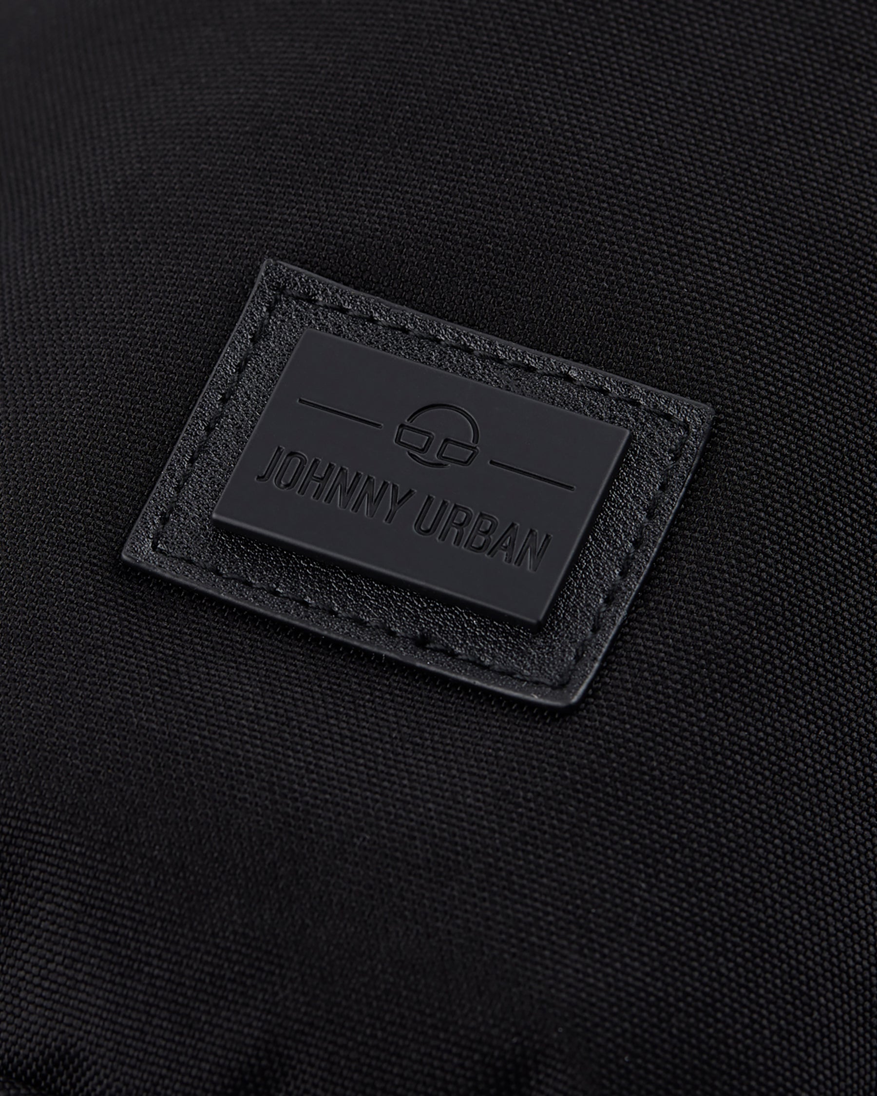 Schwarzes Logoetikett mit Schriftzug 'Johnny Urban' auf nachhaltiger Umhängetasche 'Rue'